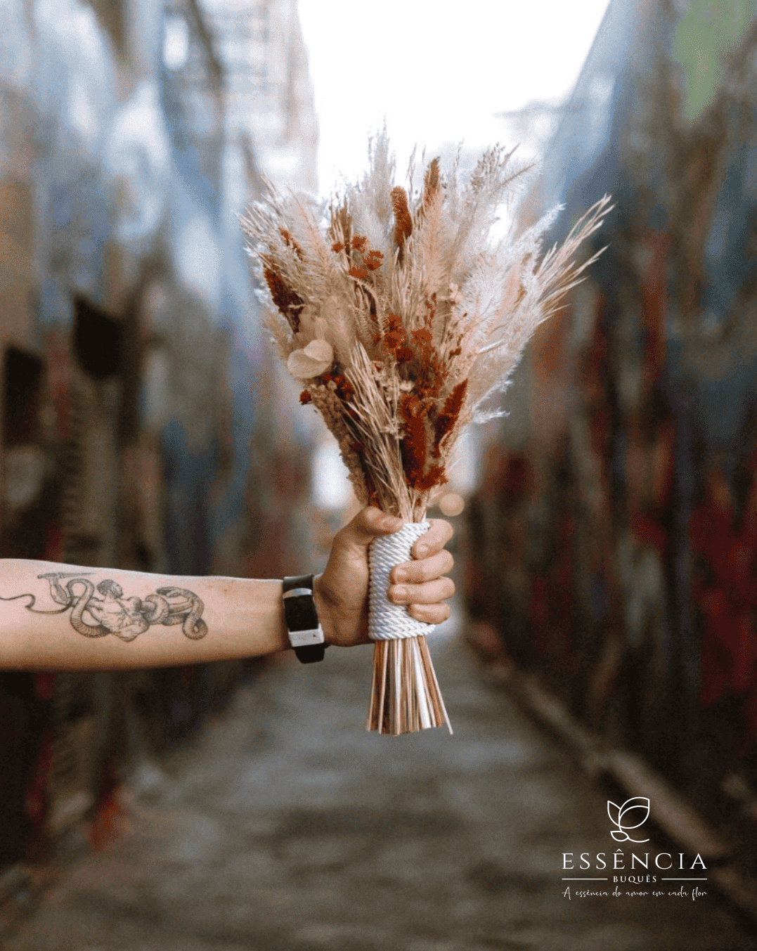 Buquê de flores desidratadas em tons verde, palha e vermelho com folhagem e fita decorativa, ideal para casamento civil.