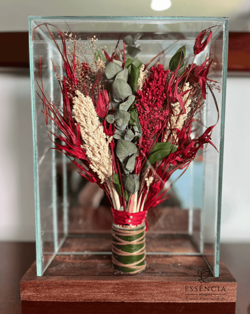 Buquê de flores desidratadas em tons verde, palha e vermelho com folhagem e fita decorativa, ideal para casamento civil.
