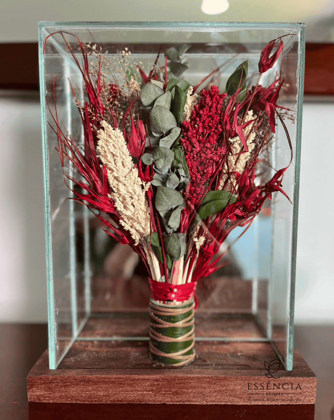 Buquê de flores desidratadas em tons verde, palha e vermelho com folhagem e fita decorativa, ideal para casamento civil.
