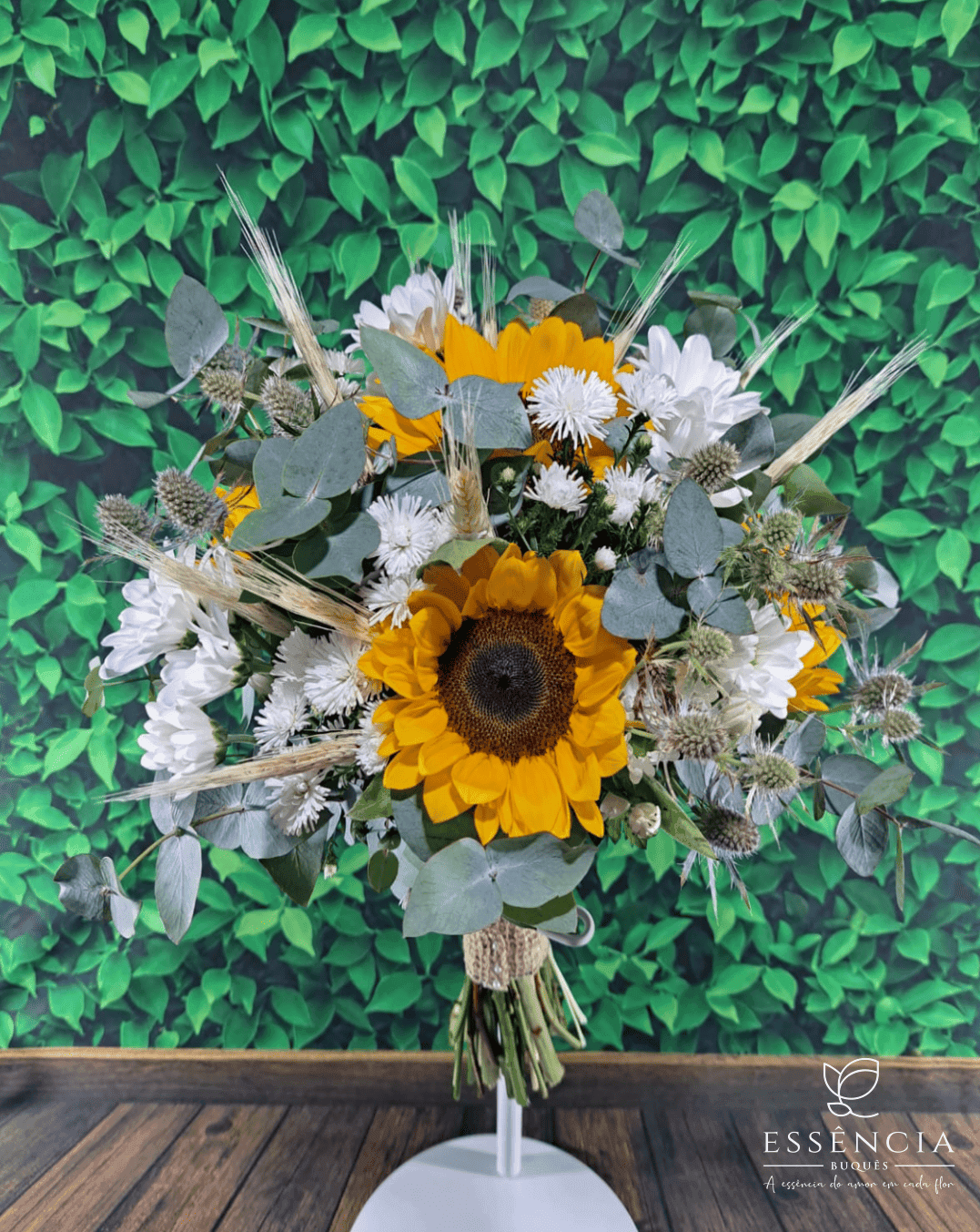 Buquê de girassol amarelo com folhagem e fita decorativa, ideal para casamento civil e religioso.