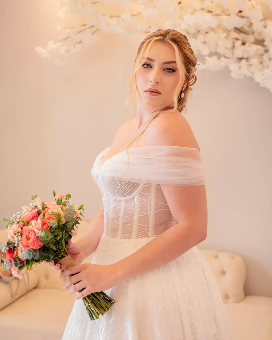 Buquê colorido, desconstruído com tons rosa e laranja claros, vermelho com folhagem e fita decorativa, ideal para casamento religioso.